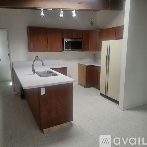 A kitchen with brown cabinets and a white counter top.