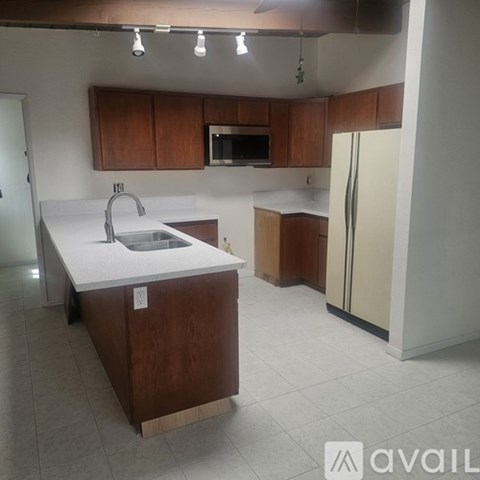 A kitchen with brown cabinets and a white counter top.