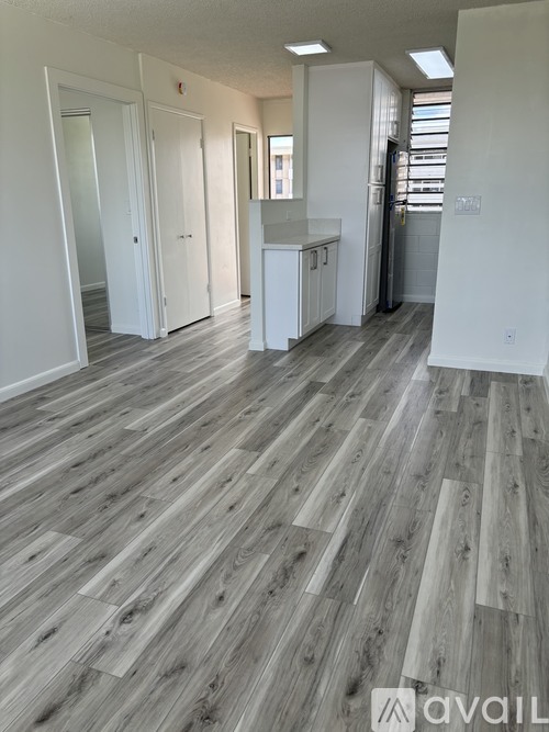 A room with wooden flooring and white walls.