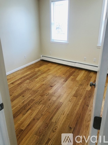 A room with wooden flooring and a window.