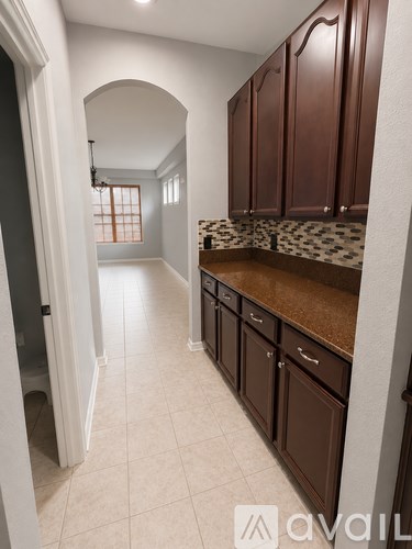 A kitchen with brown cabinets and a tiled floor.
