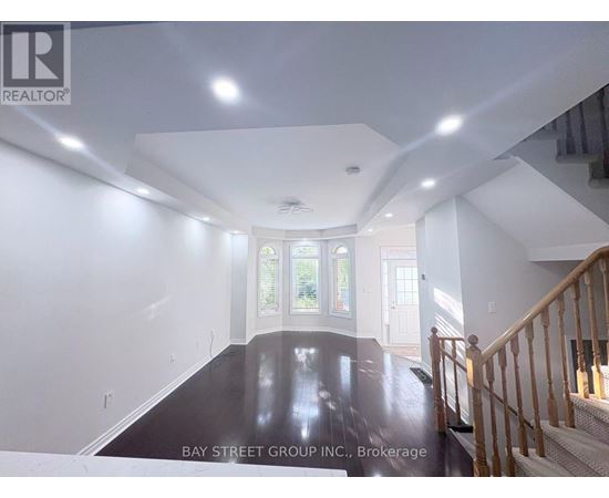 A spacious room with a staircase leading to the second floor.