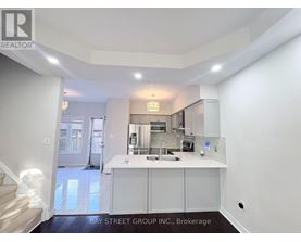 A kitchen area with white cabinets and a countertop.