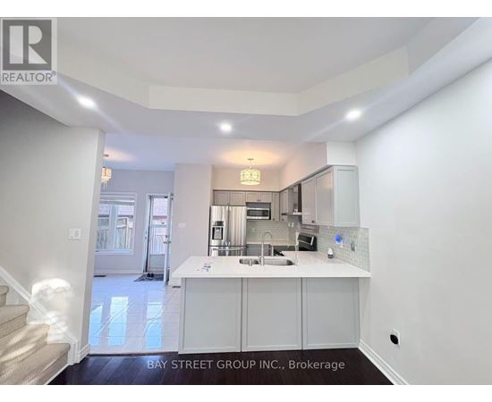 A kitchen area with white cabinets and a countertop.