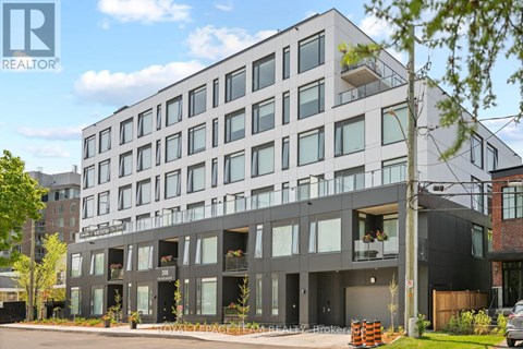 A modern multi-story building with balconies and a glass facade.