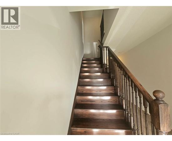 A wooden staircase with a railing on the side.