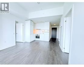 A spacious, empty room with white walls and a wooden floor.