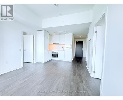 A spacious, empty room with white walls and a wooden floor.