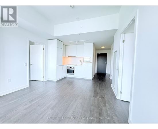 A spacious, empty room with white walls and a wooden floor.
