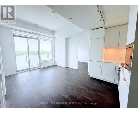 A spacious room with wooden floors and white walls.
