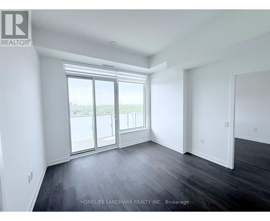 A spacious room with a view of the outside through the sliding glass door.
