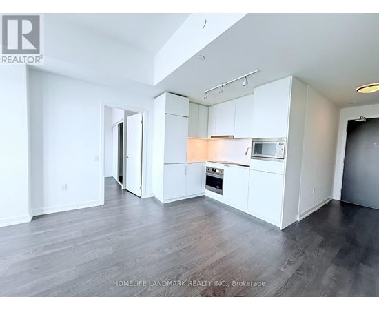 A spacious kitchen with white cabinets and a microwave above the oven.