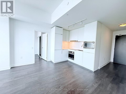 A spacious kitchen with white cabinets and a microwave above the oven.
