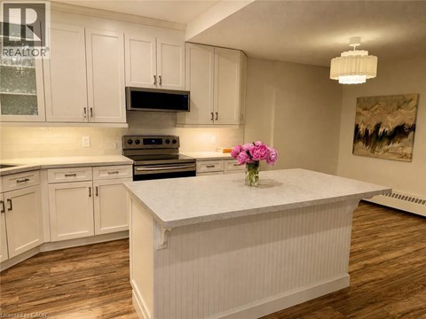 A kitchen with white cabinets and a white island.