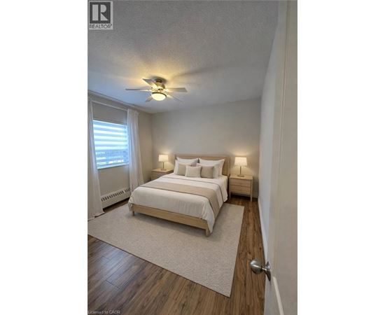 A bedroom with a bed, nightstands, and a ceiling fan.