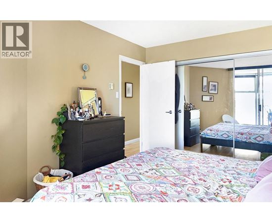 A bedroom with a bed, dresser, and mirror.