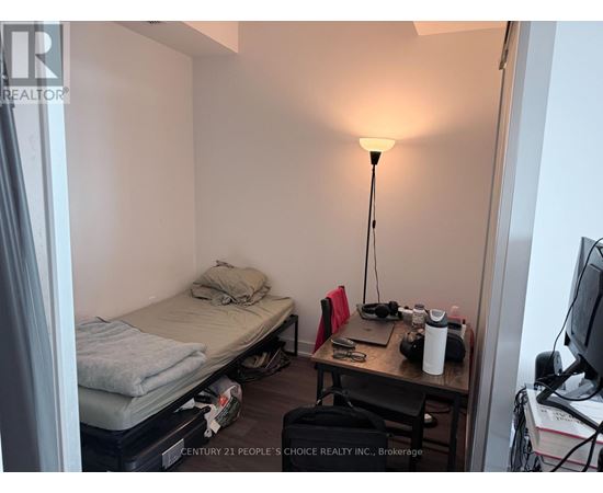 A small room with a bed, desk, and lamp.