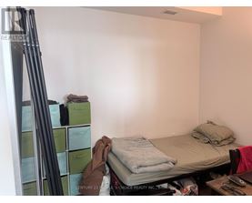 A bedroom with a bed, a desk, and a ladder.