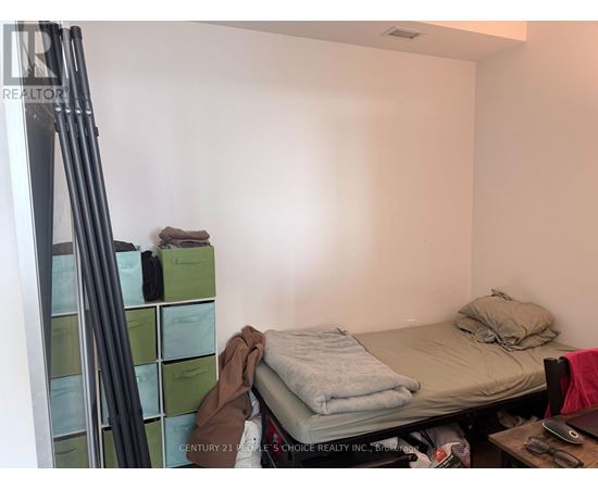 A bedroom with a bed, a desk, and a ladder.