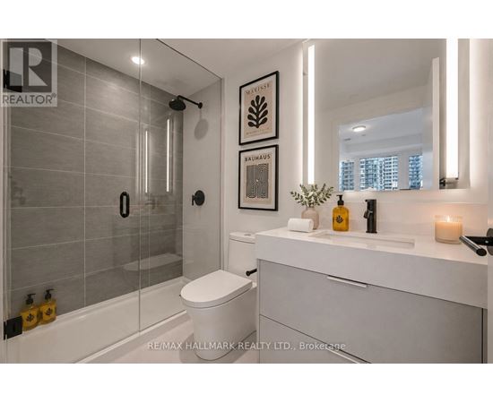 A modern bathroom with a glass shower stall and a white toilet.