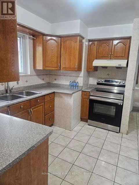 A kitchen with wooden cabinets and a marble countertop.