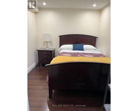 A bedroom with a bed, nightstand, and lamp.