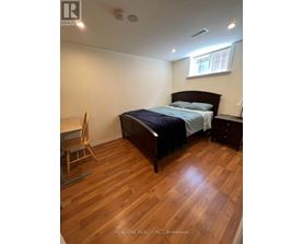 A bedroom with a bed, nightstand, and chair.