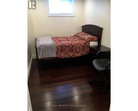 A bedroom with a bed and a chair.