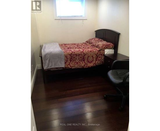A bedroom with a bed and a chair.