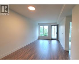 A room with wooden floors and white walls, with a sliding glass door leading outside.