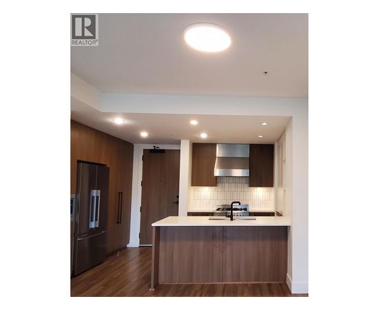 A modern kitchen with dark wood cabinets and a white countertop.