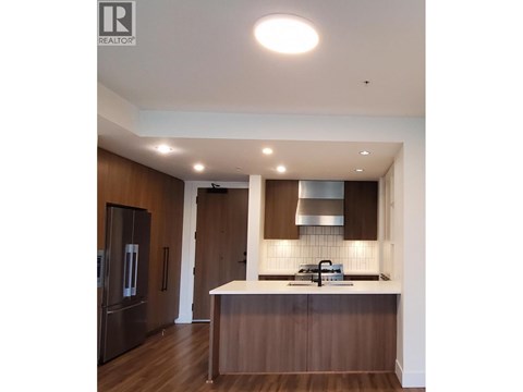A modern kitchen with dark wood cabinets and a white countertop.