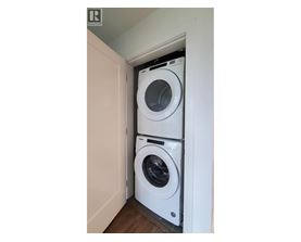 A white washing machine is in a small space.