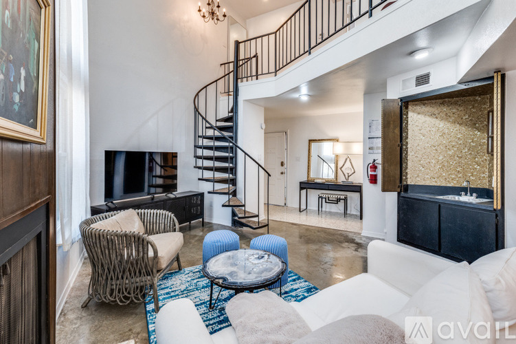 A living room with a spiral staircase and a television.