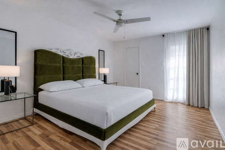 A bedroom with a large bed and a ceiling fan.