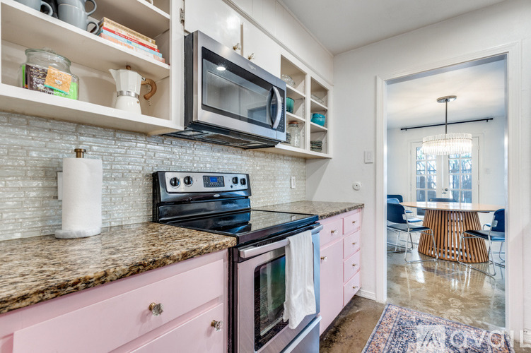 A kitchen with pink cabinets and a granite countertop.