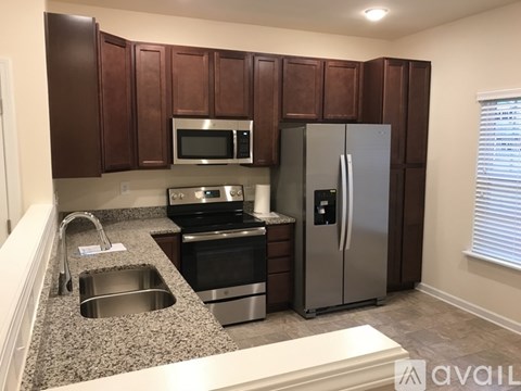 A kitchen with brown cabinets and stainless steel appliances.
