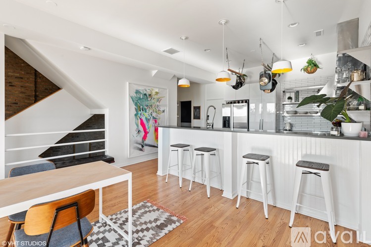 A modern kitchen with white cabinets and a bar area.