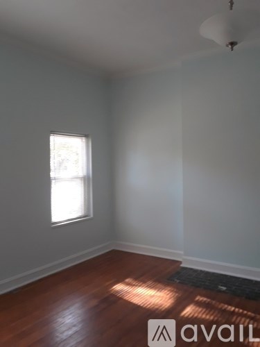A room with a window and wooden floors.