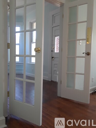 A white door with a gold handle is open.