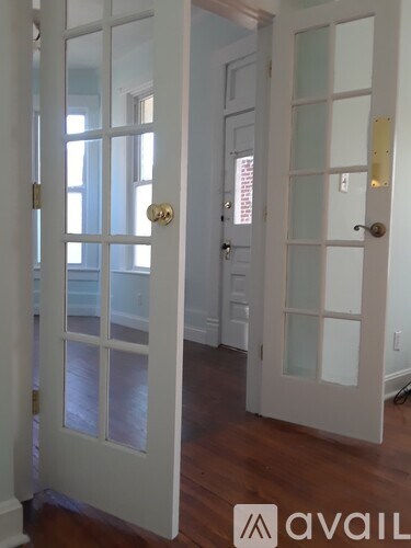 A white door with a gold handle is open.
