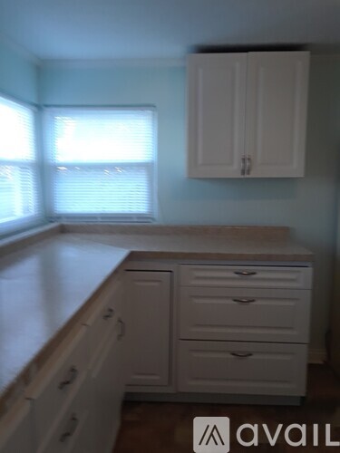 A kitchen with white cabinets and drawers.