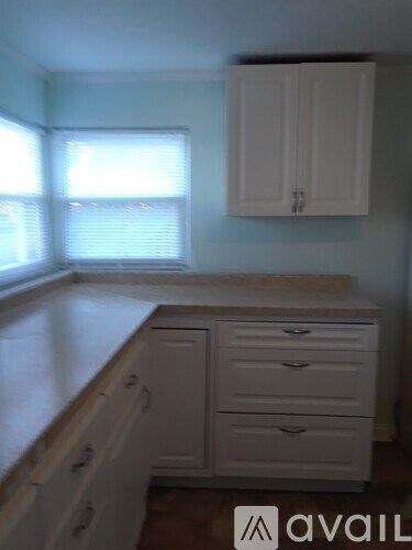 A kitchen with white cabinets and drawers.