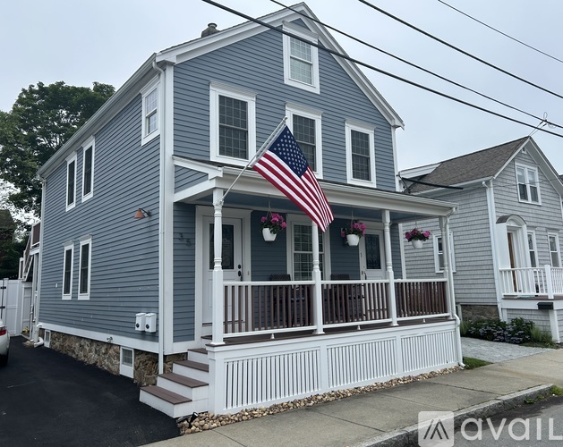 A house with a porch and an American flag hanging from the roof.