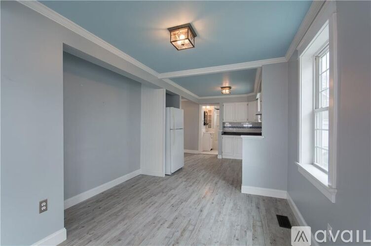 A room with a light blue ceiling and wooden flooring.