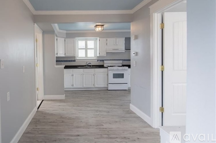 A kitchen with white cabinets and a black stove top oven.