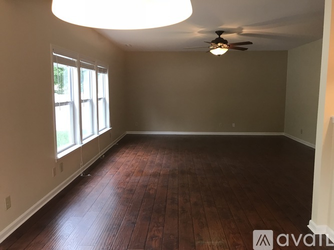 A room with wooden floors and a ceiling fan.