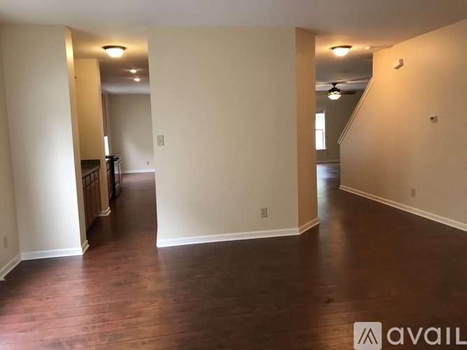 A spacious room with wooden floors and white walls.
