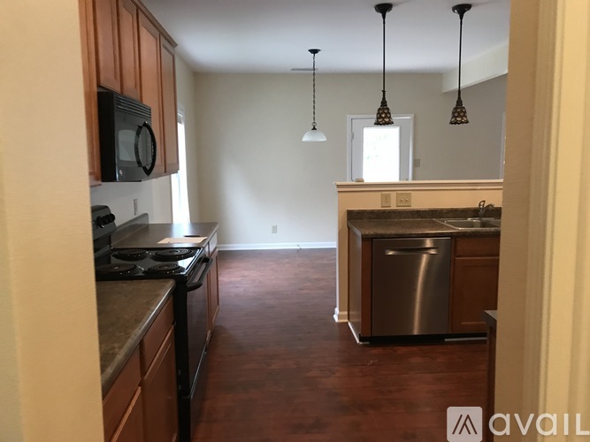 A kitchen with wooden cabinets and a stainless steel dishwasher.