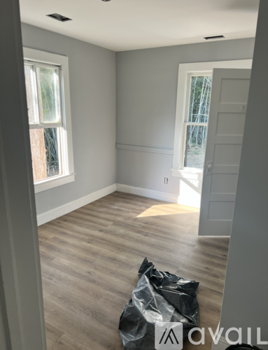 A room with wooden flooring and a window.